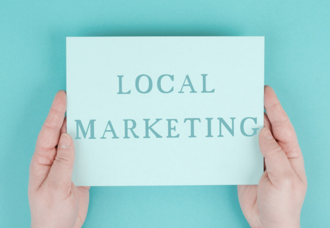 Someone holding a sign that says Local Marketing